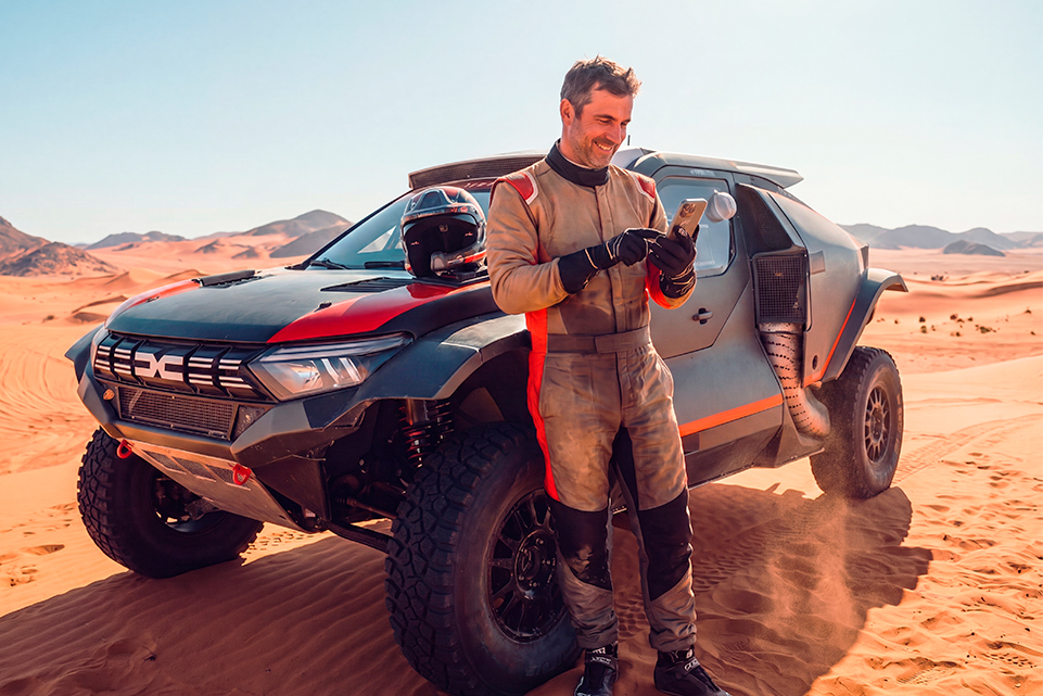 Adventure sports with a Mega Millions jackpot: driver beside a rally car in the desert