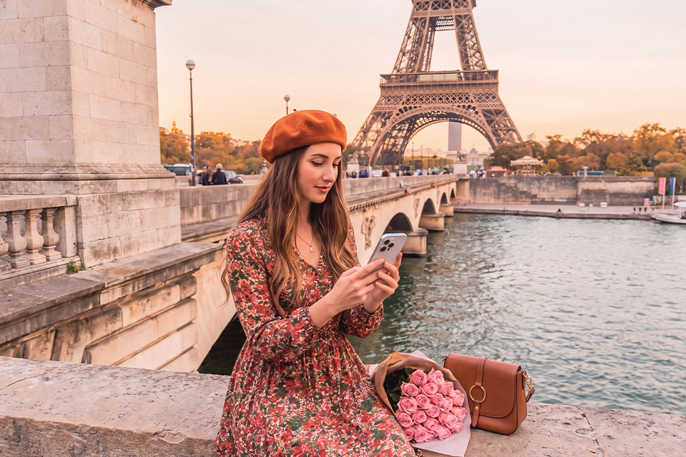 Woman sightseeing in Paris near the Eiffel Tower, imagining Labor Day Powerball travel dreams